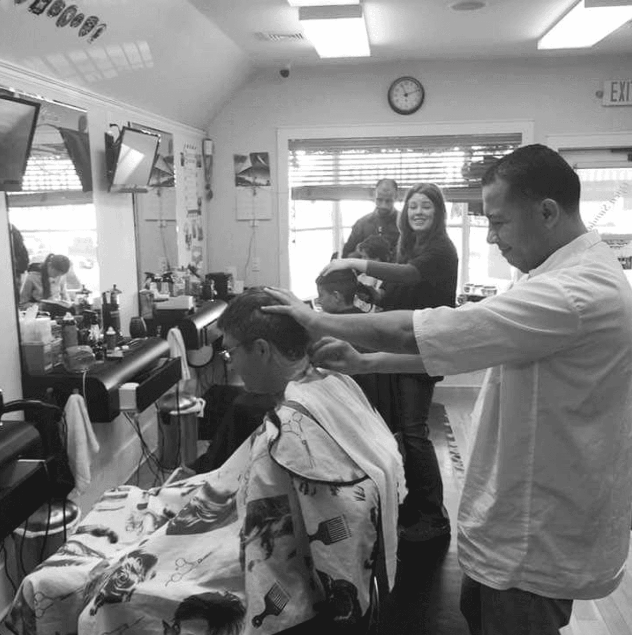Naim, owner of Fresh Cuts NY, giving a haircut in the shop